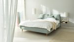 JOKA Arte Boxspringbett in Hellgrün mit weißer Bettwäsche und Holzfüßen im hellen Schlafzimmer