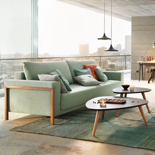JOKA Time Doppelliege in Mintgrün mit Holzakzenten in geschlossener Sitzposition in einem modernen Loft mit großem Fensterfront-Ausblick.