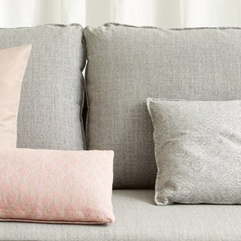 JOKA Zierkissen Lino auf einem grauen Sofa mit rosa und grauen Zierkissen.