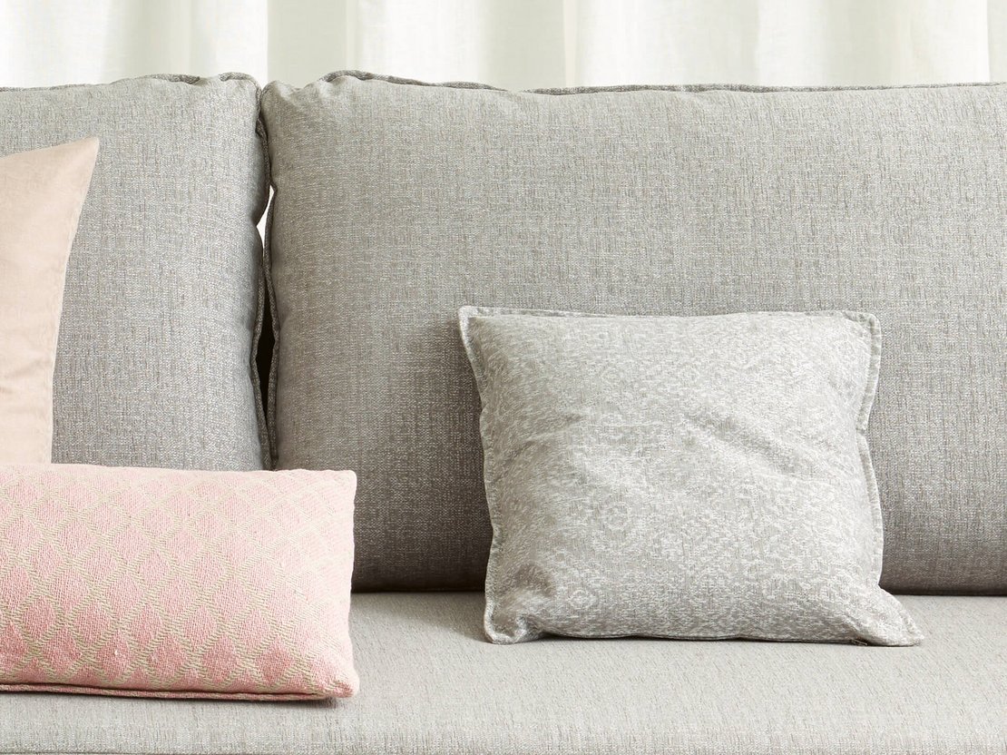 JOKA Zierkissen Lino auf einem grauen Sofa mit rosa und grauen Zierkissen.