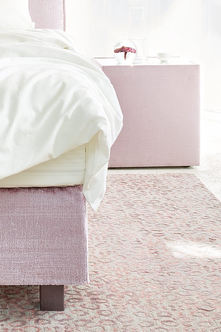 Detailansicht der Fußvariante vom JOKA Capri Boxspringbett in Altrosa mit dunklem Holzfuß