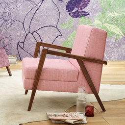 oka Laguna lilafarbener und rosa Fauteuil mit Hocker vor floral gemusterter Tapete