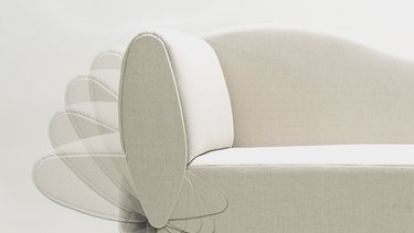 Nahaufnahme des Armteils der hellbeigen JOKA Classique Chaiselongue mit überlagerter Bewegungsdarstellung, um die Klappfunktion zu zeigen.