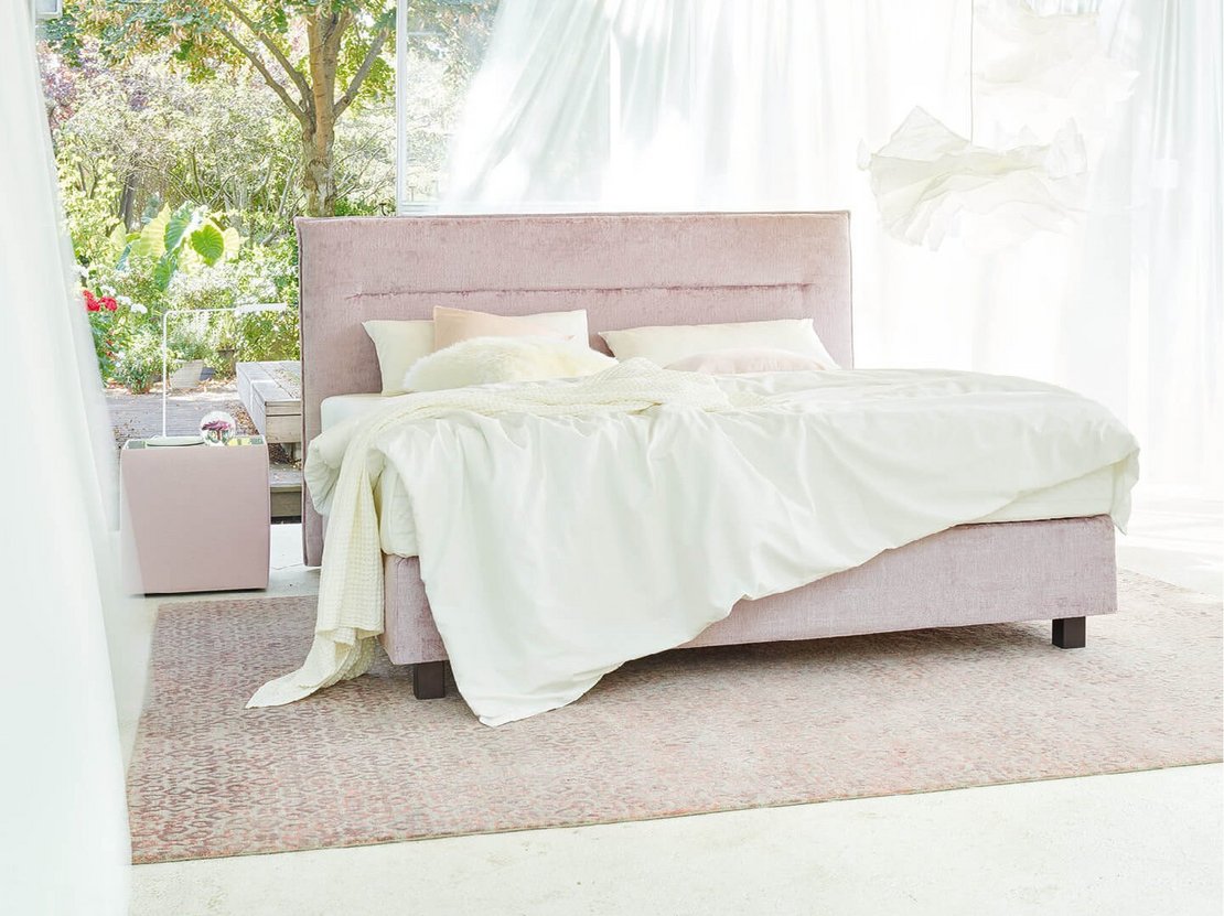JOKA Capri Boxspringbett in Altrosa in der Totalen im modernen, lichtdurchfluteten Schlafzimmer mit Holzdecke