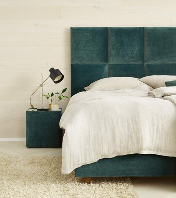JOKA Piazza Boxspringbett in grünem Samt im Hochformat mit passendem Nachtkästchen und Tischleuchte