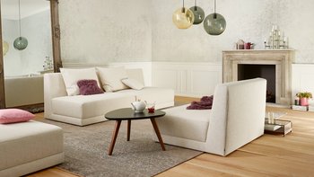 Joka Laguna beige Sessel- und Couch-Module mit Rückenlehnen vor stilvollem Kamin